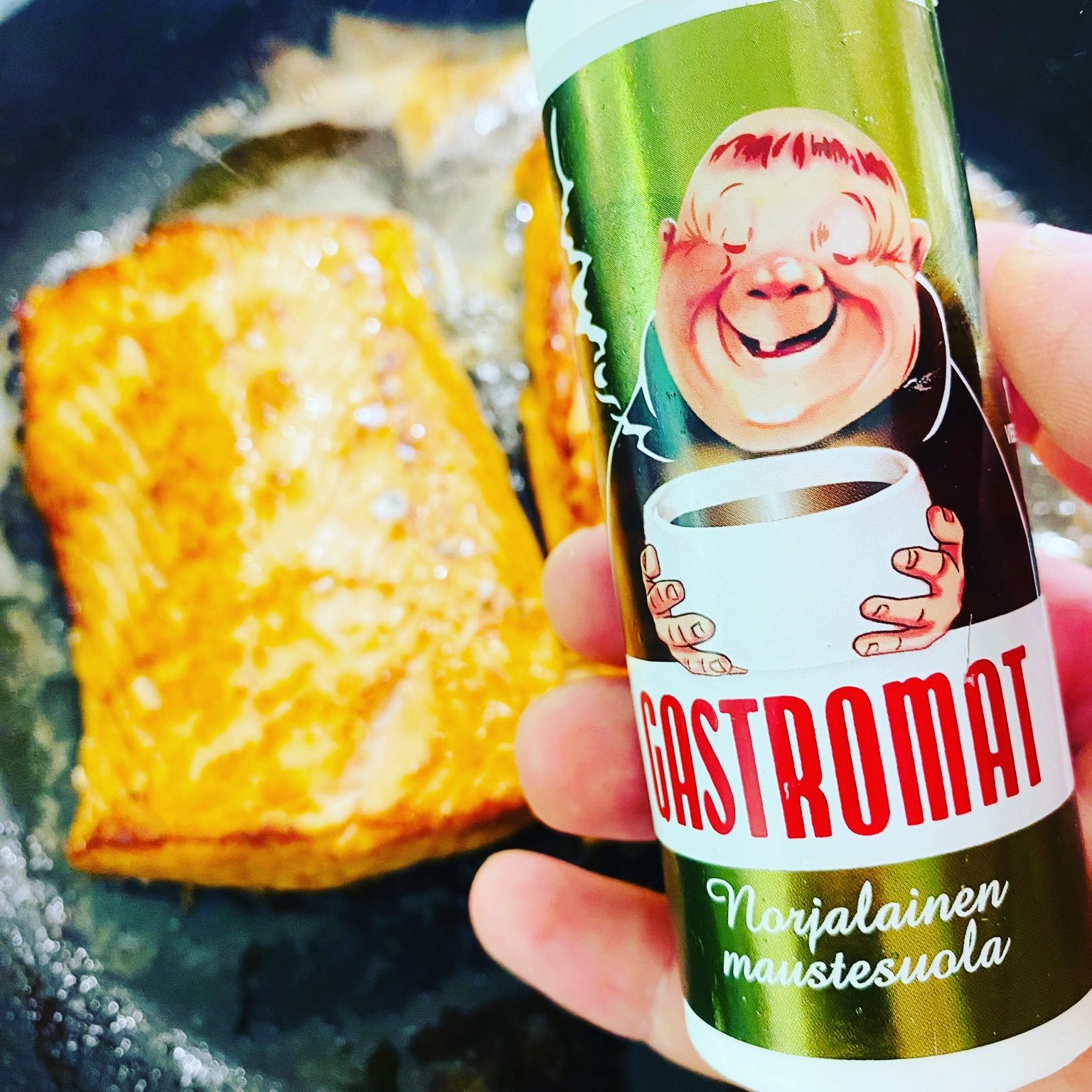 Pannulla paistettua kullan väristä lohta ja Gastromat maustesuolapurkki kädessä.